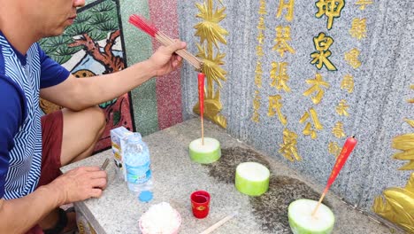 individual performing a traditional incense offering.