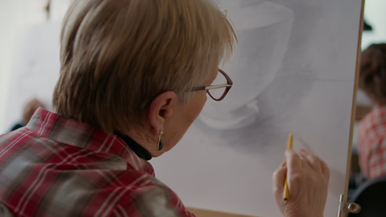 Old woman drawing model with artistic technique on canvas