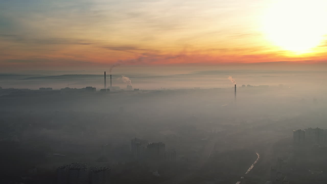 Pemandangan udara dari drone Chisinau saat matahari terbit, Moldova. Pemandangan kota dengan kabut di udara, pipa dengan uap yang berjatuhan, pemandangan kota
