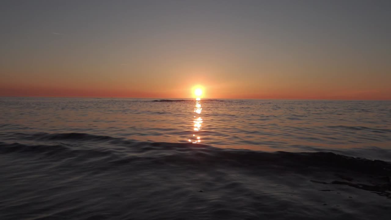 잔잔한 파도가 있는 바다 일몰, 중앙 구성이 있는 슬로우 모션