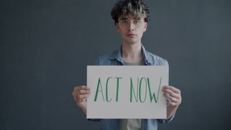 person holding a sign saying 'act now'
