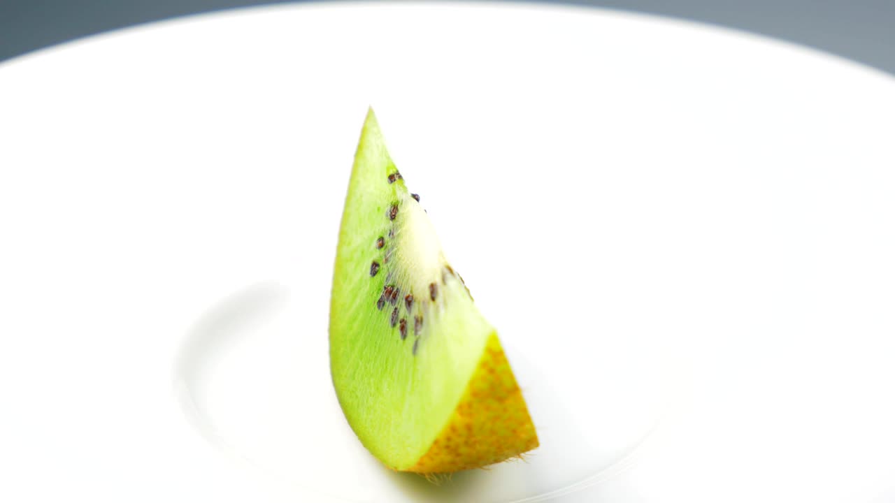 la rebanada de kiwi fresca está girando lentamente en el estudio con los detalles.