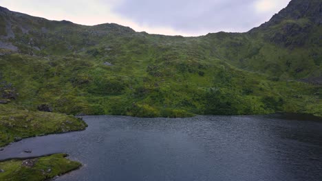 Flying-overflowing-water-being-released-from-a-reservoir-built-into-a-green-rocky-mountain-in-Scandinavia