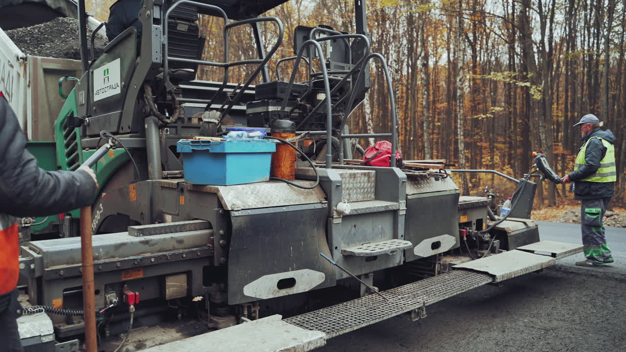 Excavator on construction works of highway. Workers making asphalt with shovels at road construction