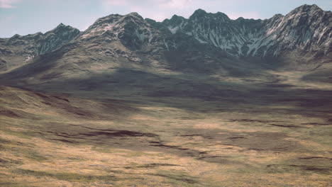 red-brown slopes and snow-capped mountain peaks