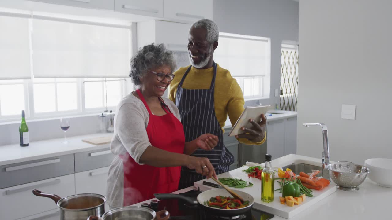 A senior African american couple cooking at home. Social distancing in quarantine