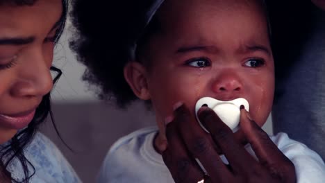 unhappy baby with pacifier crying