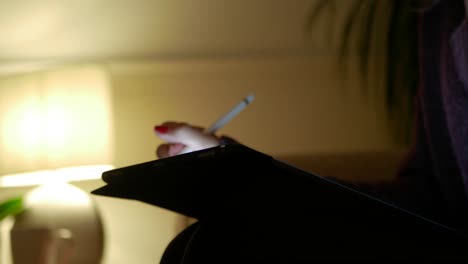 woman using a tablet during the evening