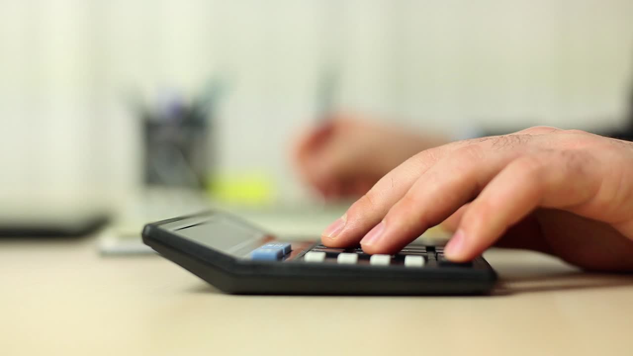 hombre de negocios trabajando con un libro y usando una calculadora 1