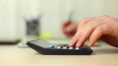 hombre de negocios trabajando con un libro y usando una calculadora 1