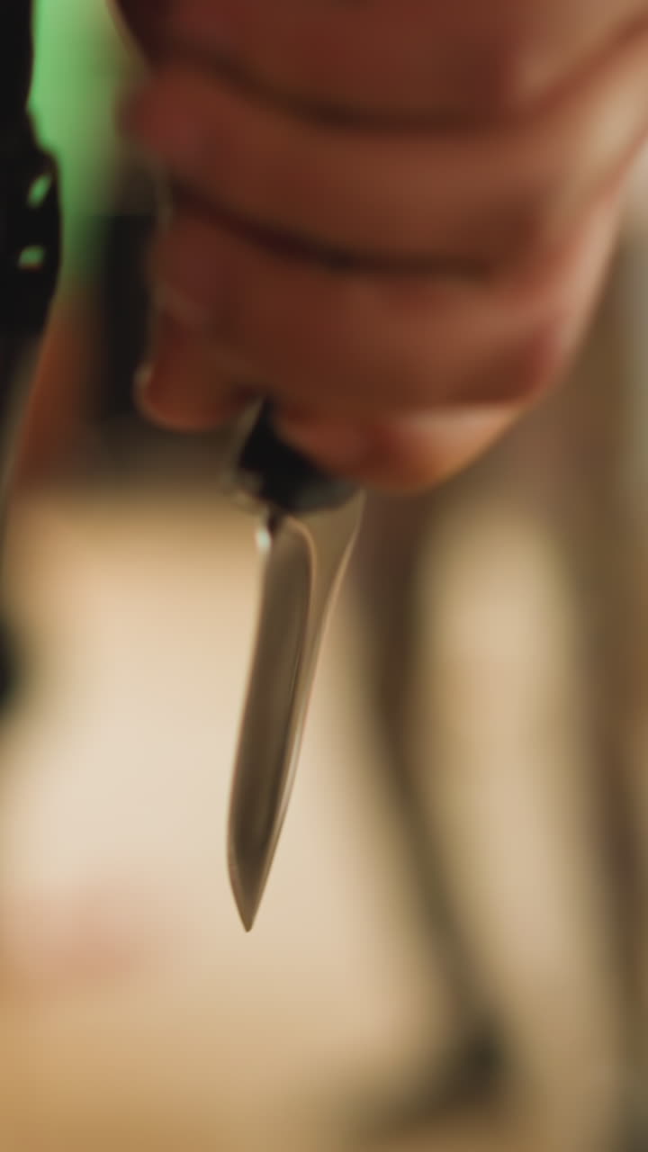 Person opens sharp knife and comes to criminal man to fight and save hostage in abandoned building hall close backside view slow motion