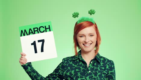 mujer que muestra un calendario con una fecha para el día de san patricio