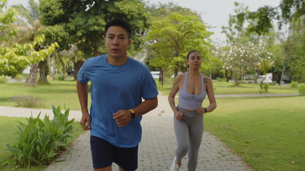 Pasangan Sporty Birasial Berlatih untuk Maraton di Taman