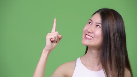 joven y hermosa mujer de negocios asiática apuntando hacia arriba