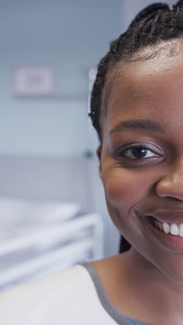 vertical video of half portrait of african american female patient in hospital room, slow motion
