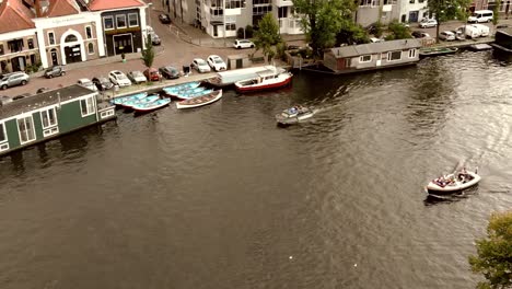 canal de haarlem con barcos que pasan por casas flotantes amarradas, países bajos - antena