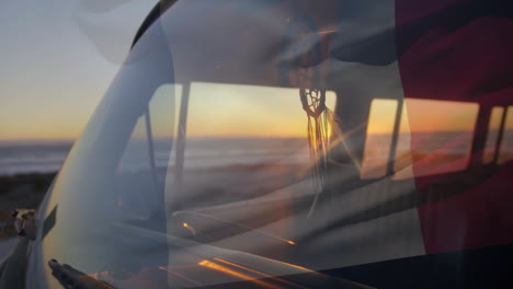 Animation-of-flag-of-france-over-campervan-on-beach-at-sunset