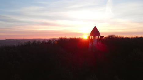 aerial zoom out of a viewpoint on a hill with sunrise in the background