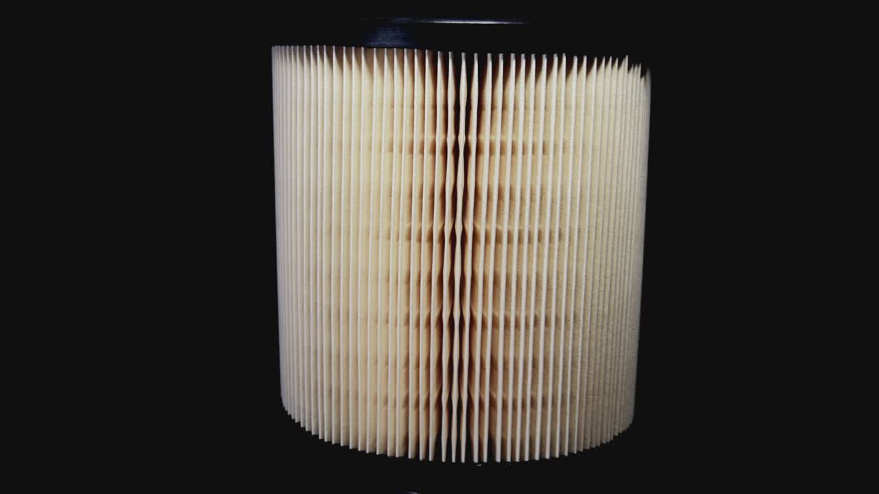 filtro de aire del coche girando sobre un plato giratorio delante de un fondo negro