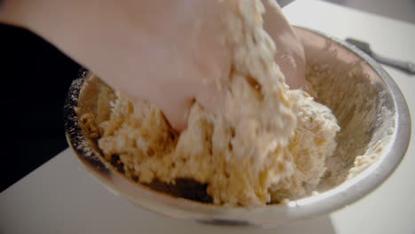 mujer joven mezclando agua y harina en un bol haciendo masa para un pastel en la cocina de casa