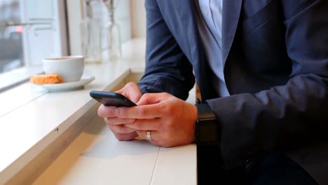 businessman using mobile phone in cafã©