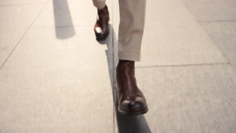 close crop of businessman feet walking in city