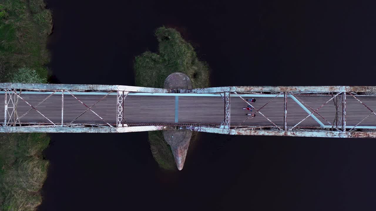People walking through bridge over river Gauja in Valmiera, Latvia