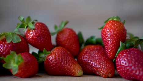 delicious homegrown beautifully red strawberries sitting on wooden countertop, pan right