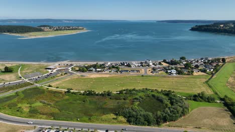 High-up-aerial-view-of-Oak-Harbor-in-Washington-State-with-waterfront-houses-and-public-park-trails-in-the-foreground