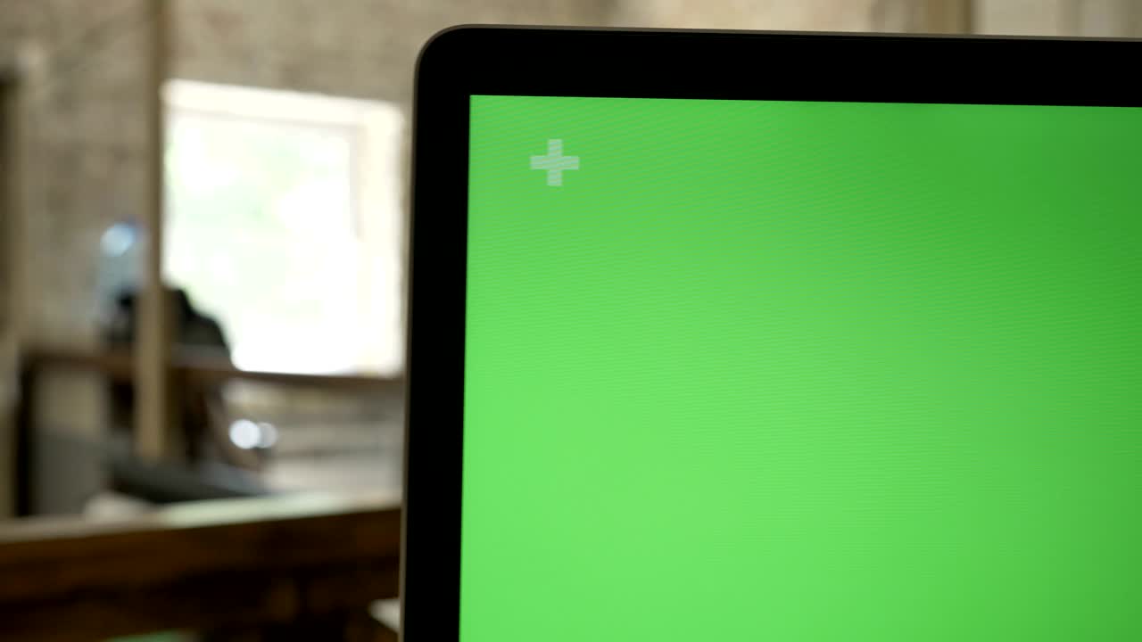 Close moving shot of computer's display with chroma key, office background