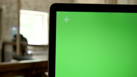 close moving shot of computer's display with chroma key, office background