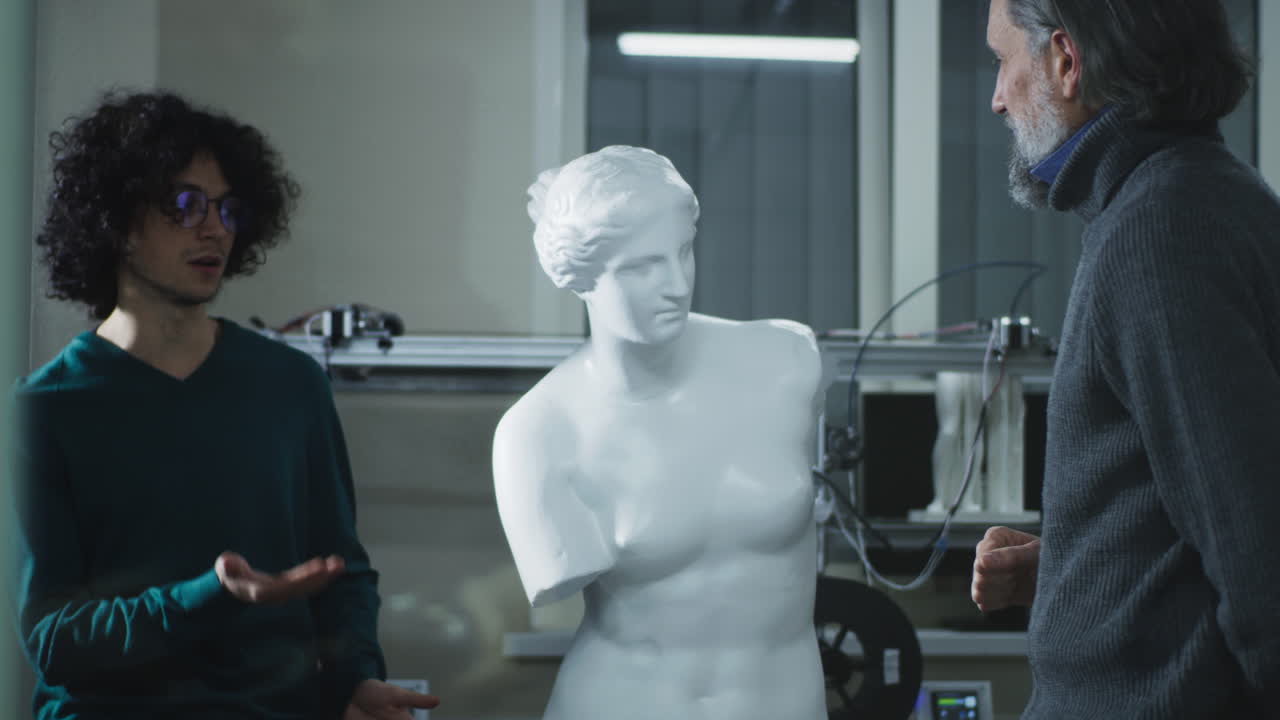 Designer and Client Discussing 3D Sculpture. Mature customer discussing plastic classic statue with young male designer then men shaking hands in agreement during meeting in 3D printing studio
