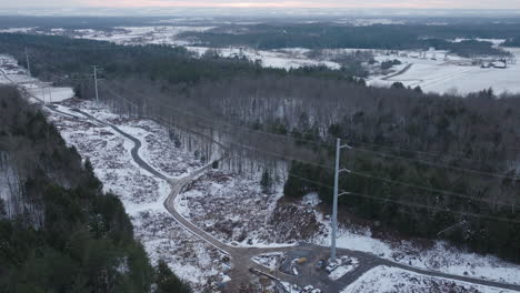 Electrical-Power-Transmission-Lines-in-a-Winter-Forest,-Aerial-Panorama