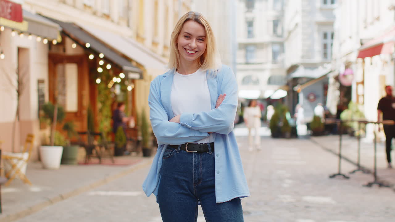 feliz mujer joven sonriendo girando mirando a la cámara descansando buenas noticias sentirse satisfecho en la calle de la ciudad