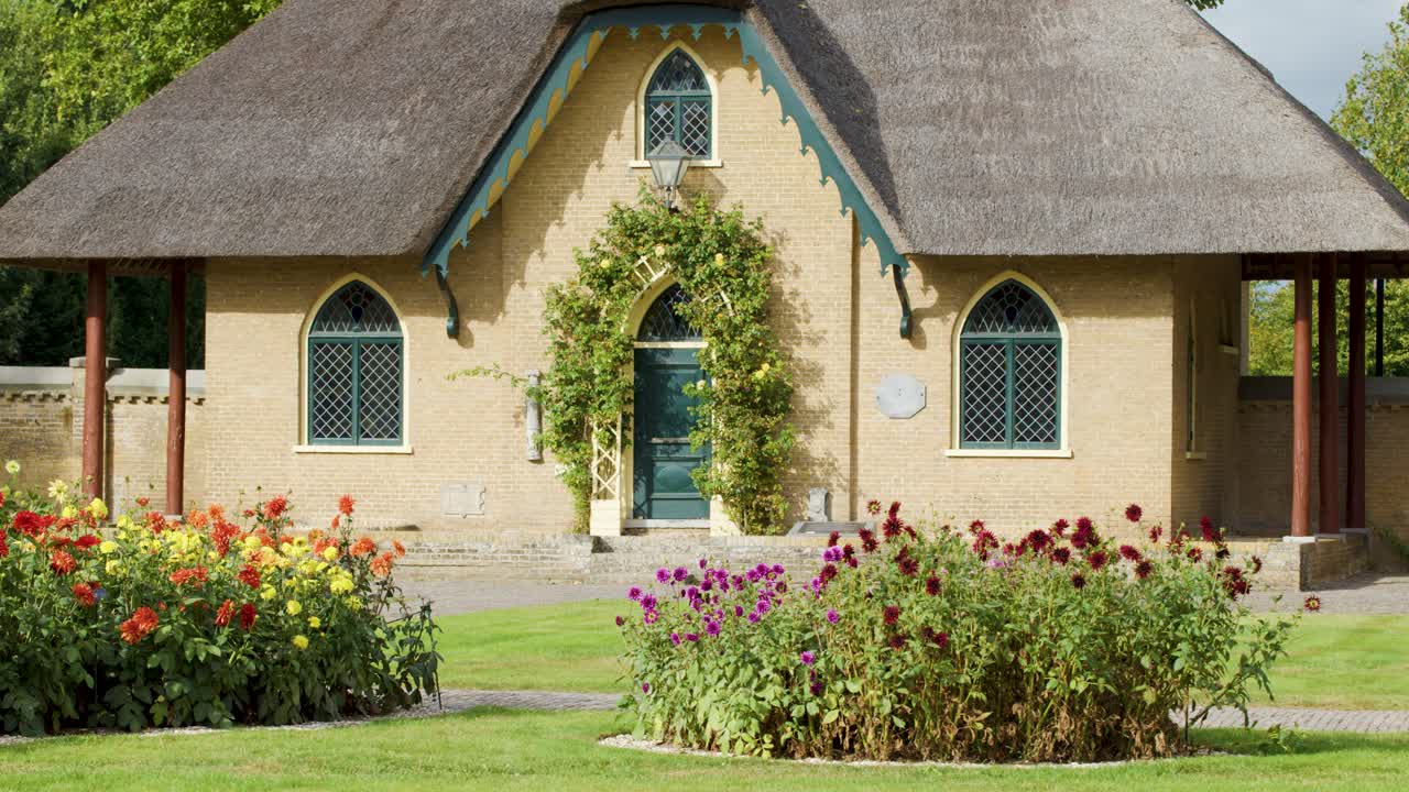Static shot of charming cottage, lush flower beds, bright daylight, soft natural colors, no people