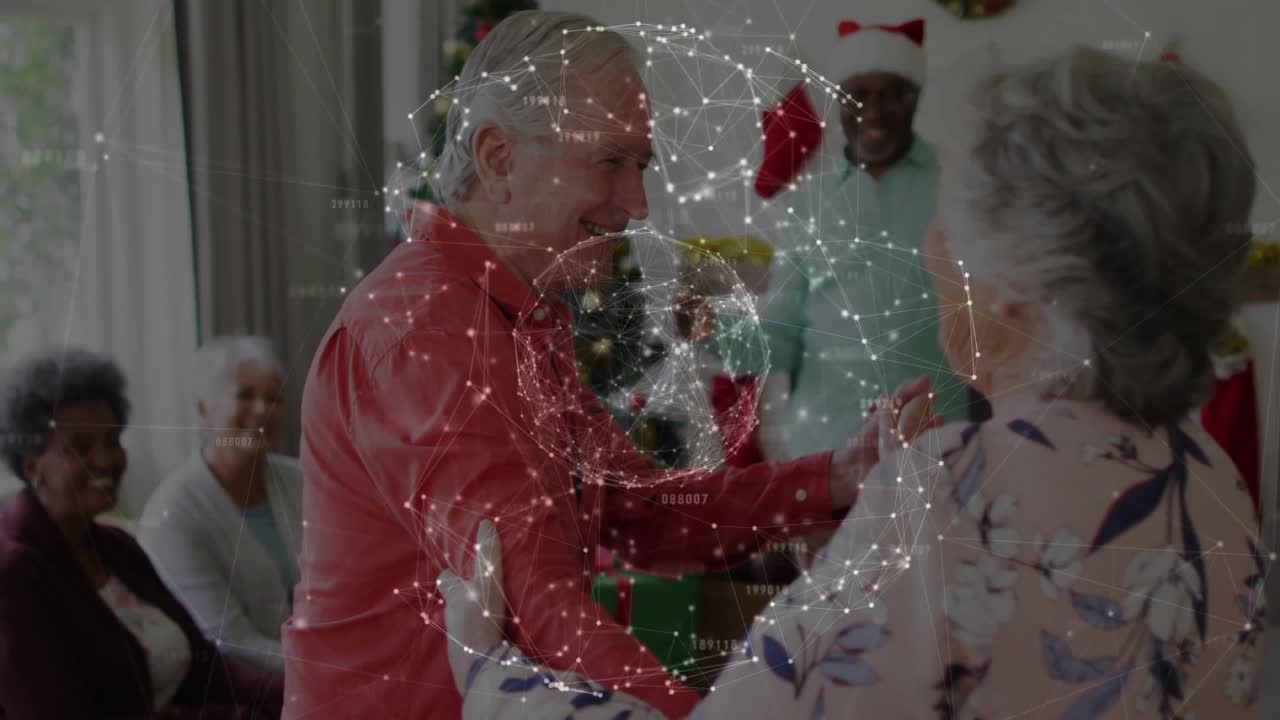 Homem idoso oferecendo a mão a uma mulher idosa e começando a rodopiar na sala de estar para uma reunião de Natal.