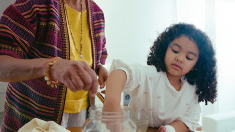 una niña negra ayudando a su abuela a cocinar en casa