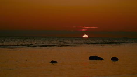 Cielo-Iluminado-Con-Hermosa-Luz-Durante-El-Amanecer-A-Través-Del-Horizonte-Marino-Y-Reflejo-En-El-Agua