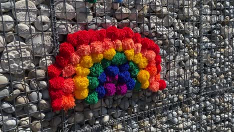 bandas de arco iris y pompones en la pared de piedra para los héroes del nhs y los trabajadores clave que luchan contra el coronavirus covid-19