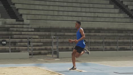 Close-up-view-of-mixed-race-athlete-doing-long-jump