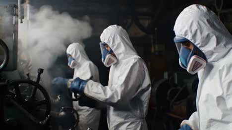 workers in protective gear operating machinery in a hazmat environment, focusing on safety and precision during industrial operations amidst steam and equipment