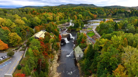 flight above the arch bridge approaching the waterfalls in ausable chasm in adirondacks. beautiful forest changing colors in autumn around.