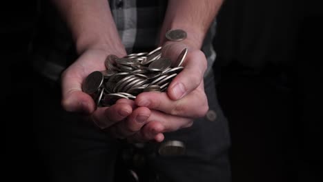 men's hands catch a pile of coins falling from above