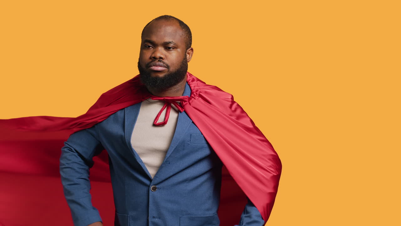 hombre con una capa posando como superhéroe en disfraz, fondo de estudio