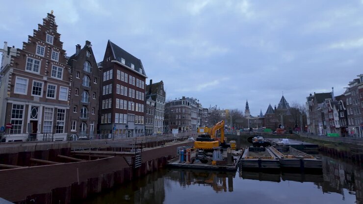 Cantiere su un canale con edifici tradizionali e una gru ad Amsterdam