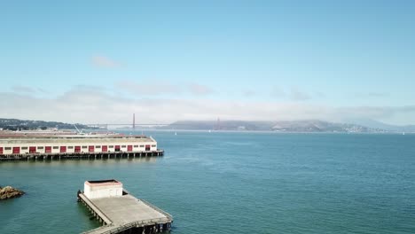 antena que asciende por encima del puerto de agua para revelar el puente golden gate en el fondo