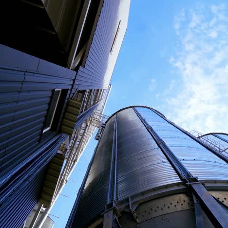 industrial grain storage tanks. large silver elevators for processing grain. modern silos. close-up. view from below.