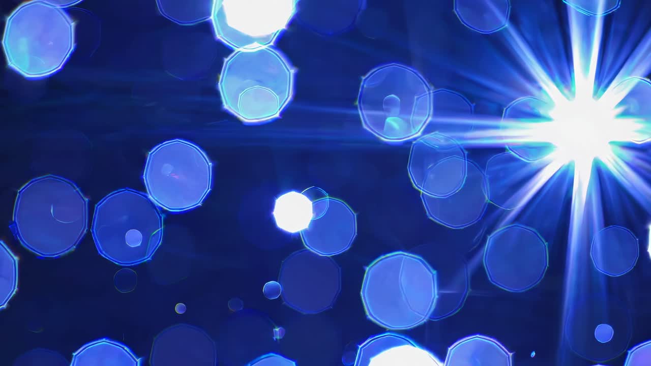 Abstract video of blue bokeh lights with a starburst effect, captured from a high angle