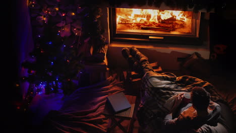 top view of a young man who is resting by the fireplace with an ashka of tea