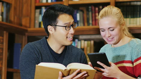 Lächelnder-Koreanischer-Mann,-Der-Mit-Einer-Frau-In-Der-Bibliothek-Spricht-1